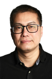 Man with glasses and dark shirt, looking at the camera.